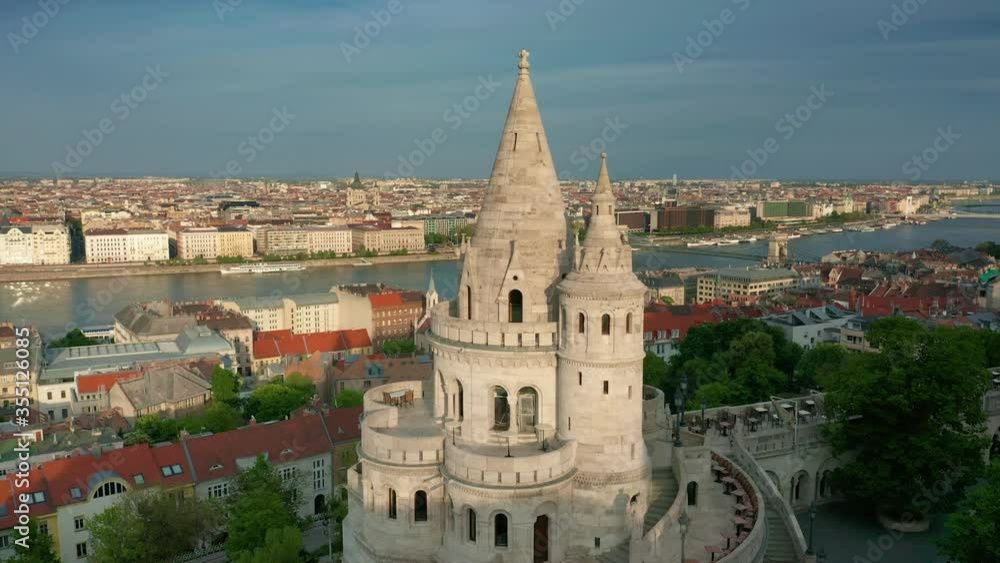 Budapest, Hungary - 4K drone flying around the tower of Fisherman's Bastion on a quiet summer morning with Parliament building at background Budapest, Hungary - 4K drone flying around the tower of Fisherman's Bastion on a quiet summer morning with Parliament building at background