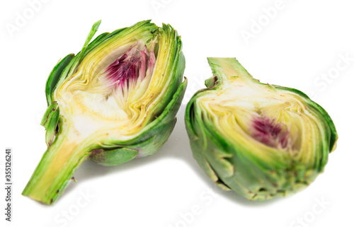 two halves of ripe green artichokes on a white background