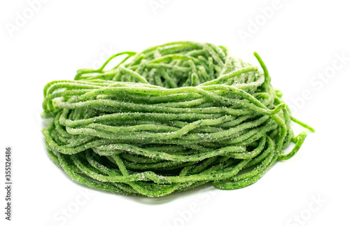 Fresh raw bio spaghetti pasta with spinach isolated on white background