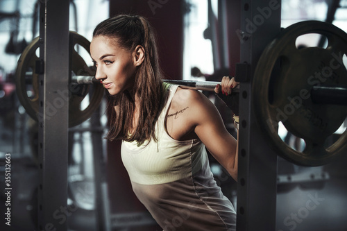 girl with a barbell in a sports club