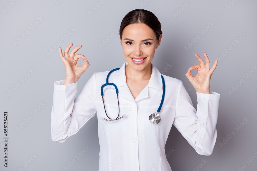 Photo of beautiful cheerful family doc experienced professional say patient good news covid test negative result hands okey symbols wear medical uniform stethoscope isolated grey background Photo of beautiful cheerful family doc experienced professional say patient good news covid test negative result hands okey symbols wear medical uniform stethoscope isolated grey background