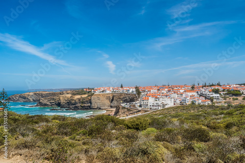 Maritime vegetation on a hill overlooking the village of Zambujeira do Mar gradient cliffs along the horizon that accompany the scenery of the seascape, Vicentine Coast Natural Park - Odemira PORTUGAL