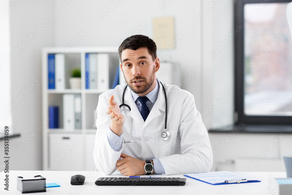 healthcare, medicine and people concept - male doctor with stethoscope having video conference at hospital healthcare, medicine and people concept - male doctor with stethoscope having video conference at hospital