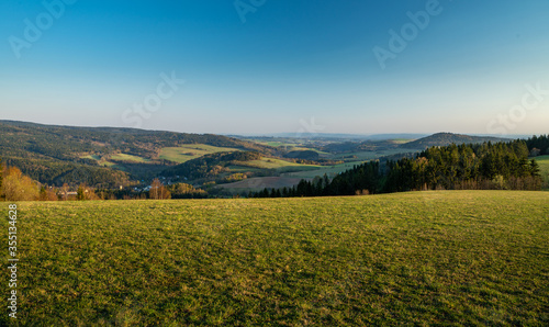 autumn landscape with green field and blue sky