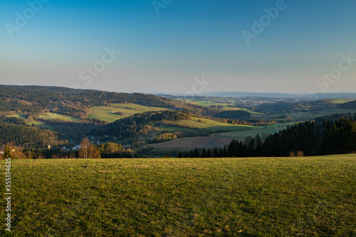 autumn landscape with green field and blue sky