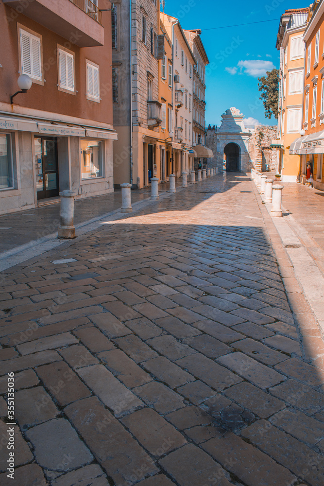 Streets in the old town of Zadar, Croatia. The famous Sea Gate to the marina in the background