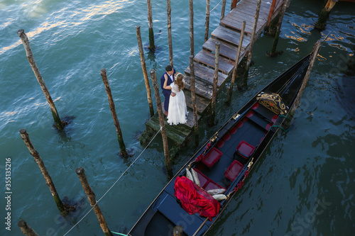 Beautiful wedding couple posing on dock in venice © hreniuca
