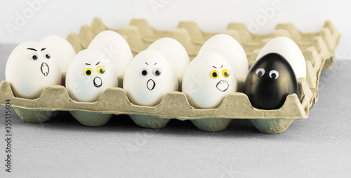 Obraz na płótnie Black egg among angry racist xenophobic white eggs - abstract of anti - racism Black Lives Matter protest in Minneapolis. w salonie
