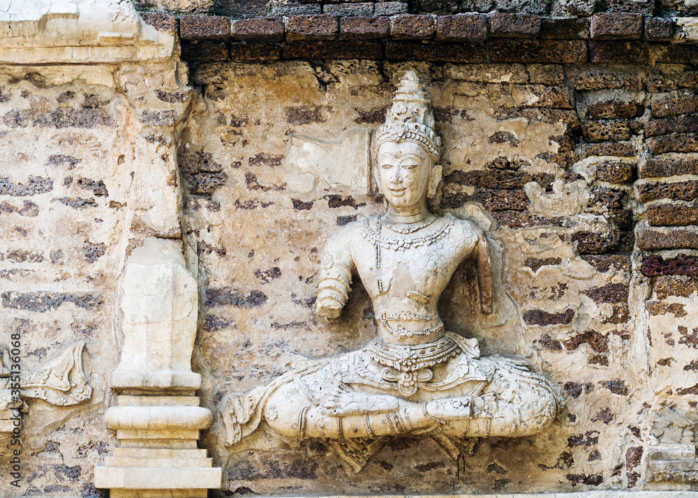 Old damaged stucco reliefs carvings of Buddha on the facade of Maha chedi, Wat Chet Yot, Chiang Mai, Thailand Old damaged stucco reliefs carvings of Buddha on the facade of Maha chedi, Wat Chet Yot, Chiang Mai, Thailand