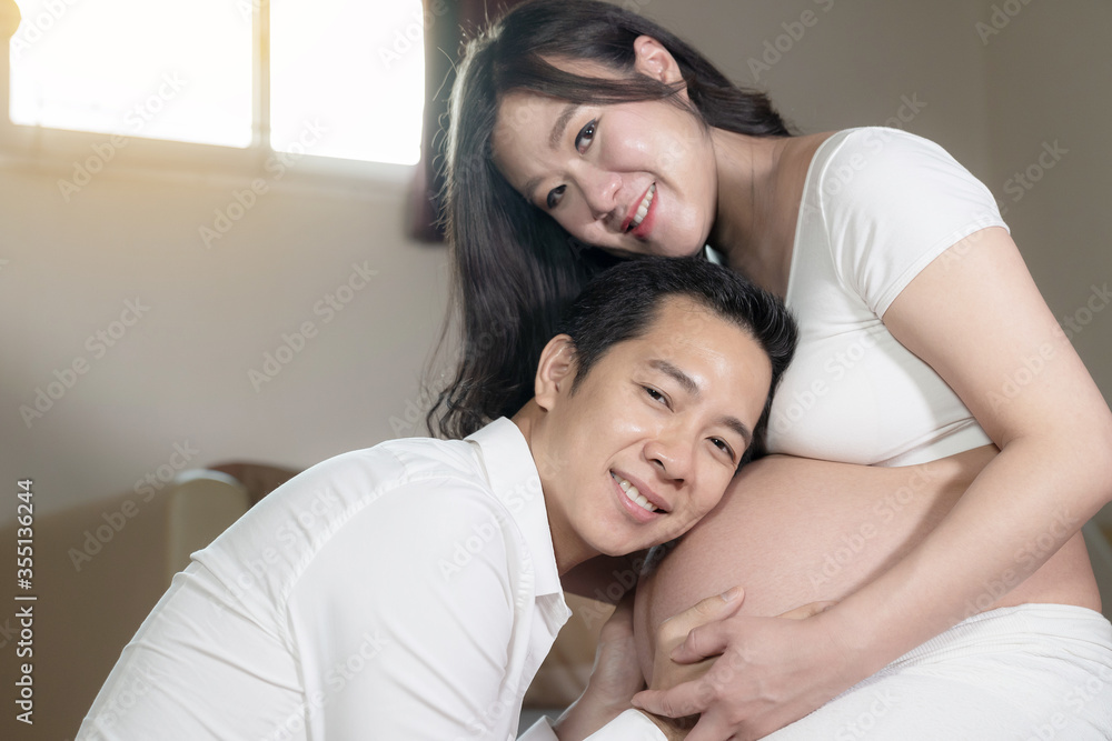 Asian couple pregnant wife and husband happiness in bedroom background. Asian couple pregnant wife and husband happiness in bedroom background.
