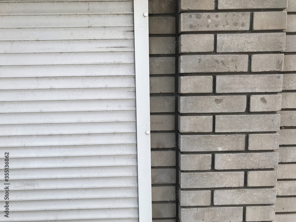 Fototapeta premium The background is two pieces, left plastic white rollettes on the right wall of white brick