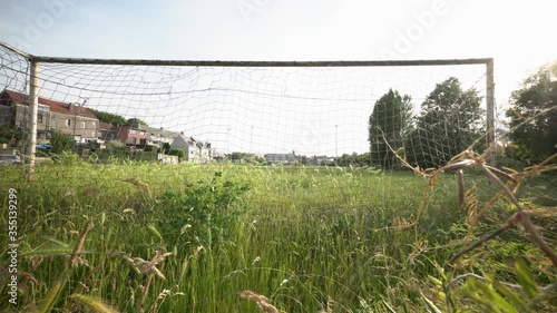 High uncut grass on soccer field. Inactivity on the pitch because of corona. Wide angle behind the goal. photo