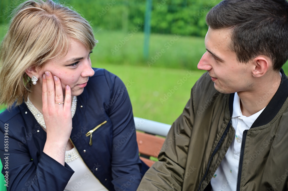 Relationship problems. Young couple is talking in the park. The concept of family communication. Relationship problems. Young couple is talking in the park. The concept of family communication.