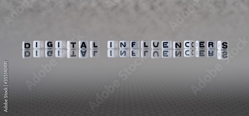 digital influencers concept represented by black and white letter cubes on a grey horizon background stretching to infinity