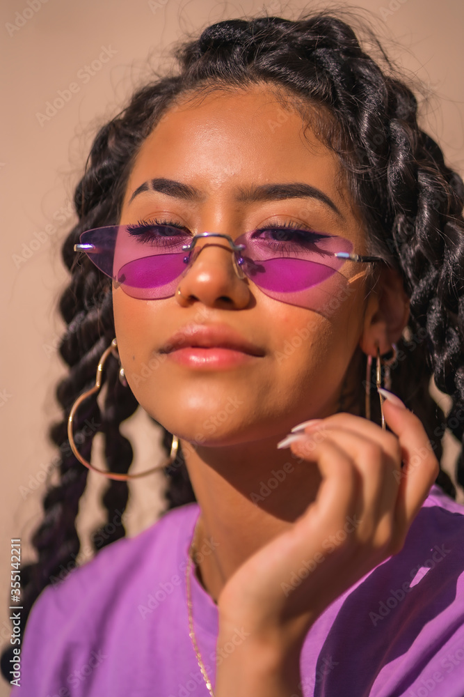 Gaze of a young brunette with purple glasses in an urban session of Latin ethnicity Gaze of a young brunette with purple glasses in an urban session of Latin ethnicity