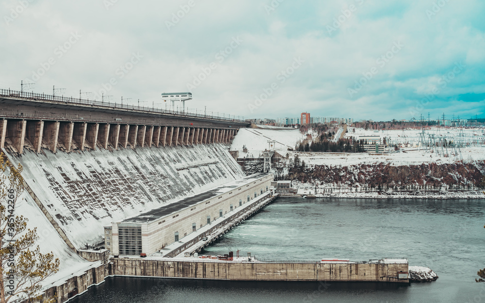 Fototapeta premium Bratskaya hydroelectric power station in winter in the snow on the Angara river