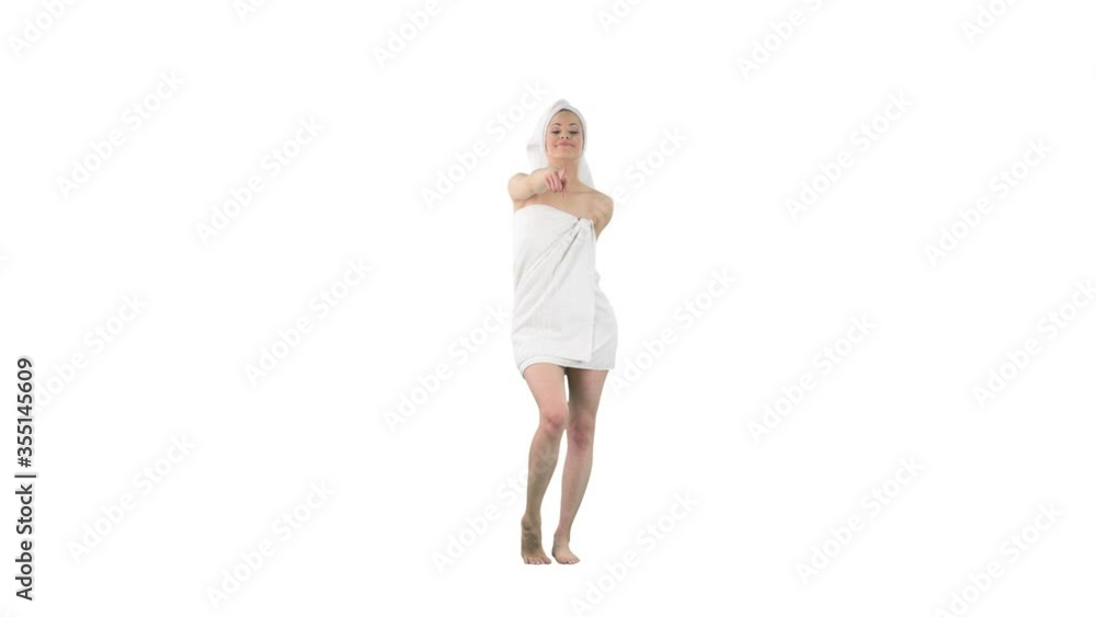 Young beauty woman in towel after bath looking at camera choosing you as winner pointing finger isolated on solid white background. Young beauty woman in towel after bath looking at camera choosing you as winner pointing finger isolated on solid white background.