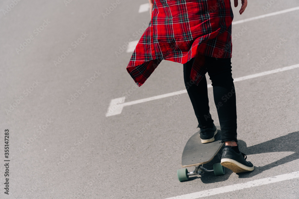 Fototapeta premium Beautiful young hipster woman with longboard on the road in the city in sunny weather