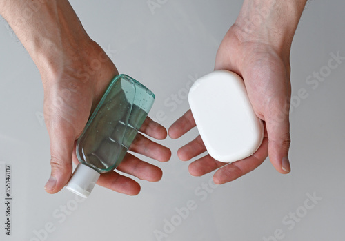 Man holding antibacterial gel hand sanitizer and antibacterial soap in his hands, coronavirus protection concept, medical background, clean hands backdrop
