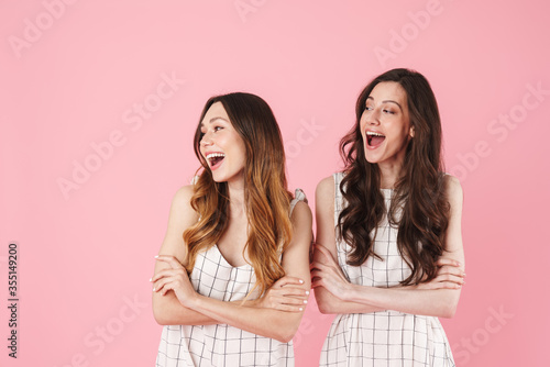 Image of joyful caucasian women laughing while posing with arms crossed