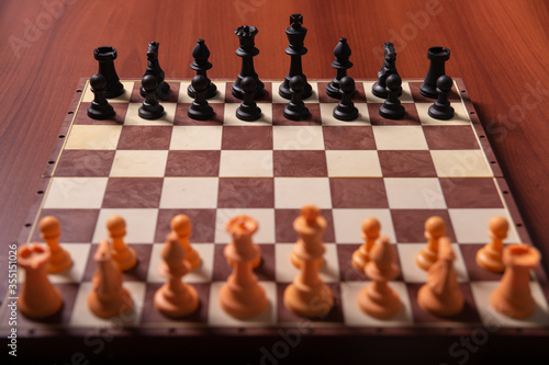 game of chess on a brown wooden table