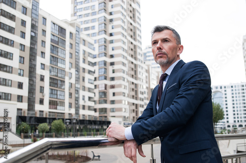 Wallpaper Mural Confident and successful. Handsome young businessman adjusting his jacket and looking away while walking outdoors with office building in the background Torontodigital.ca
