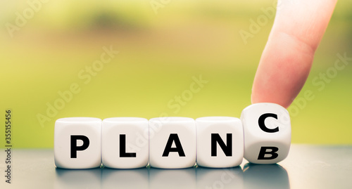 Hand turns dice and changes the expression "plan b" to "plan c".