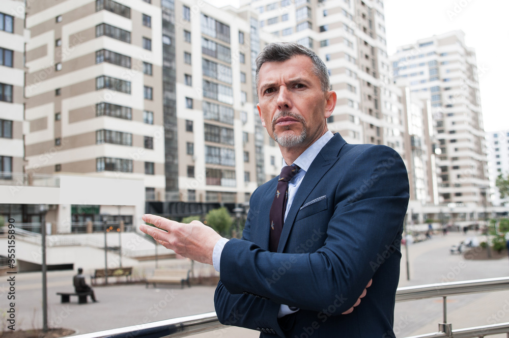 Young businessman using smartphone in the urban environment. The man in suit full length Young businessman using smartphone in the urban environment. The man in suit full length