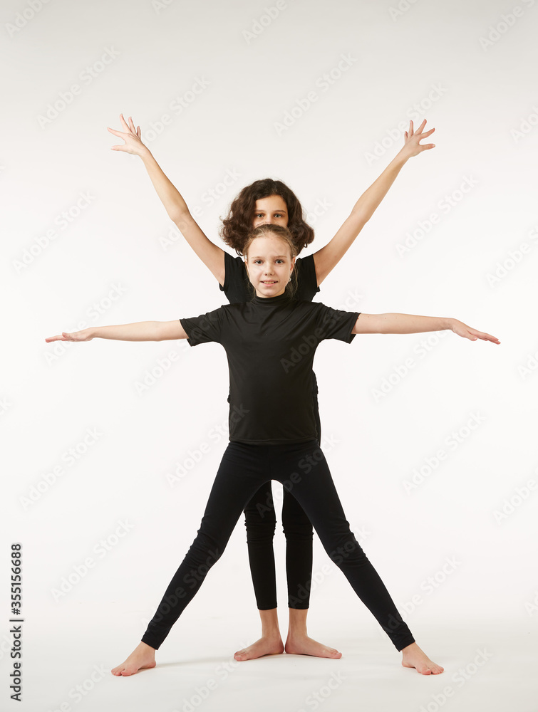 Two girls of same ages in dance poses and black clothes Two girls of same ages in dance poses and black clothes