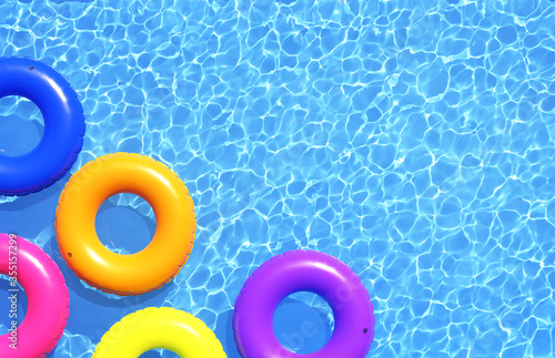 Top view of colorful swim rings on the blue water background. 