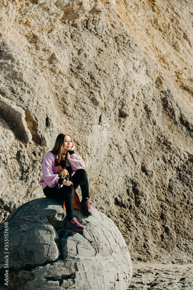 Fototapeta premium Beautiful asian woman sit on Moeraki Boulders, South Island, New Zealand.