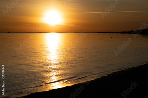 Golden sunset on the beach with beautiful reflection in the water.