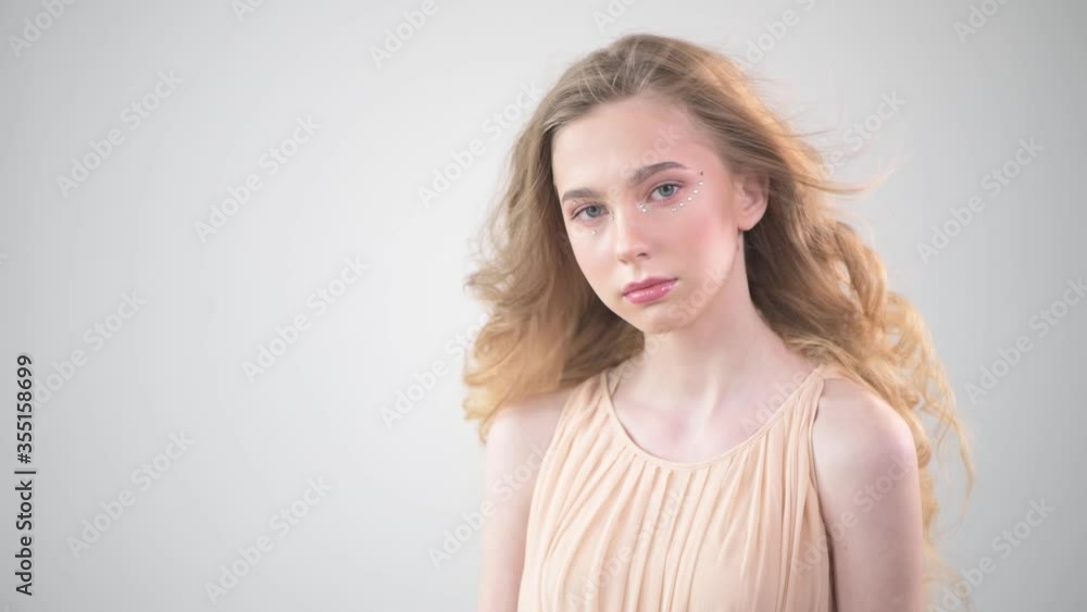 A young beautiful blonde girl looks at the camera. Decomposing hair. A young beautiful blonde girl looks at the camera. Decomposing hair.