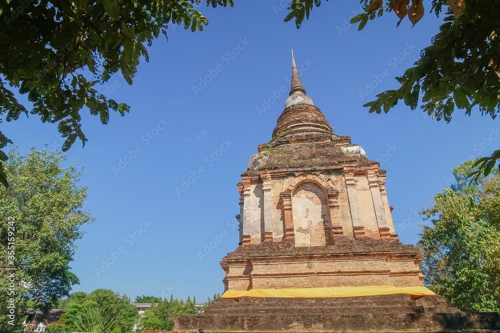 view of old ruin pagoda lanna style art 13th. Century. with blue sky background, Wat Chet Yot or officially called Wat Photharam Maha Wihan in Chiang Mai City, northern of Thailand.