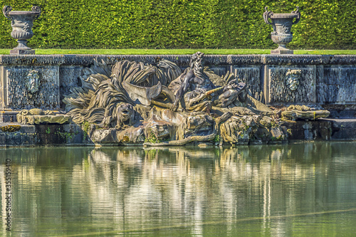 Neptune Fountain (1770) in gardens of famous Versailles palace. Palace of Versailles was a royal chateau. It added to UNESCO list of World Heritage Sites. Versailles, Paris, France.