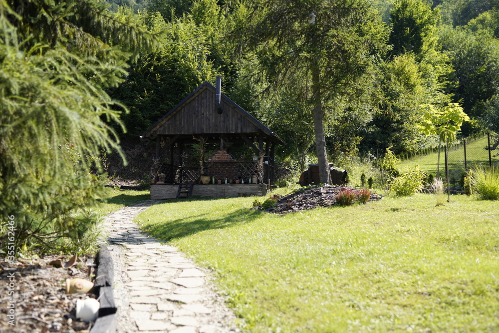 Fototapeta premium Altes Landhaus, Berhaus, Berghütte aus Holz und Stroh angebrannt, Grill, Feuerstelle, Wald, Bergurlaub, Land