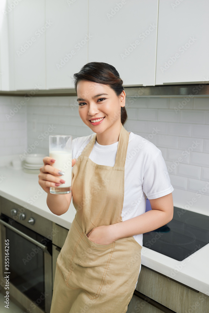 Young attractive woman with milk and healthy breakfast in kitchen Young attractive woman with milk and healthy breakfast in kitchen