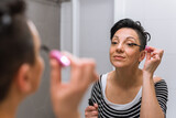 woman makeup eyelashes in bathroom