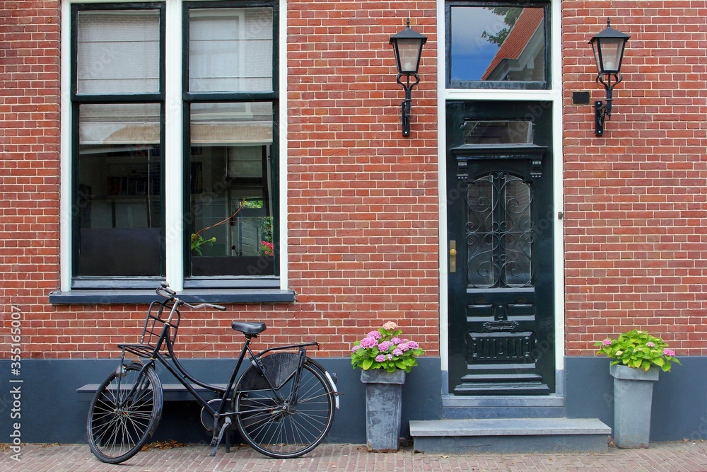 Facade of Dutch brick wall house, front door and bike, Netherlands  