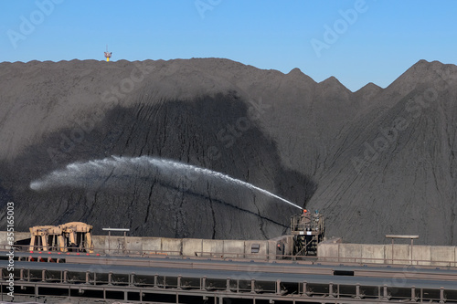 Fotografie Wetting of Iron ore stock piles at sea port cargo terminal
