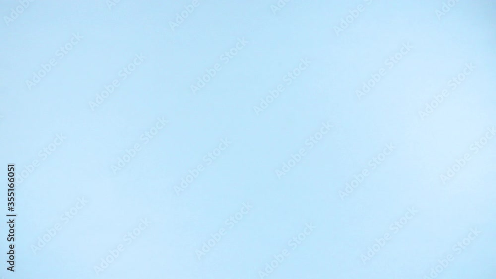 A joyful explosion of uncooked italian pasta fusilli, multicolor, flying up on a colorful light blue background in slow motion. A joyful explosion of uncooked italian pasta fusilli, multicolor, flying up on a colorful light blue background in slow motion.