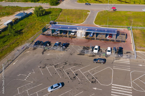 Self-service car wash. Cars are on the posts of a car wash. People wash their cars. An aerial shot.