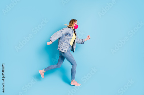 Full size profile photo of pretty lady quarantine finished run street outdoors jump high good mood shopping center direction wear face mask blazer jeans shoes isolated blue color background