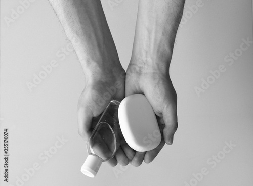 Black and white,man's hands holding hand sanitizer and antibacterial soap, man holding hygiene products black and white, virus prevention concept