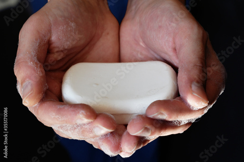 Man's hand holding a soap, man hands holding white antibacterial soap, self hygiene concept, covid-19 prevention