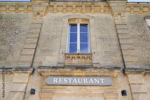 restaurant text sign with windows on old french building in city street