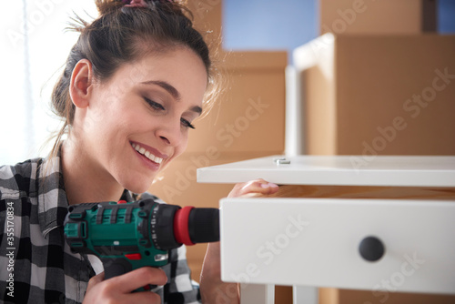 Close up of cheerful woman using electronic drill