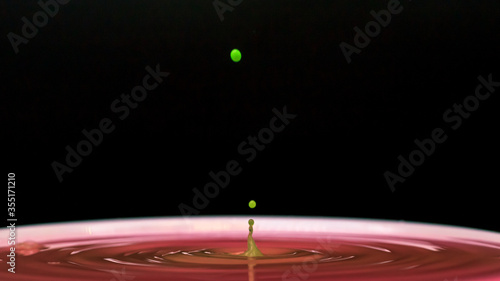 Green color drops in pink water