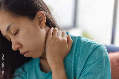 Young woman feeling exhausted and suffering from neck pain, Health concept