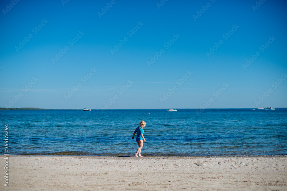 
ein kleines blondes Mädchen spielt auf der Ostsee